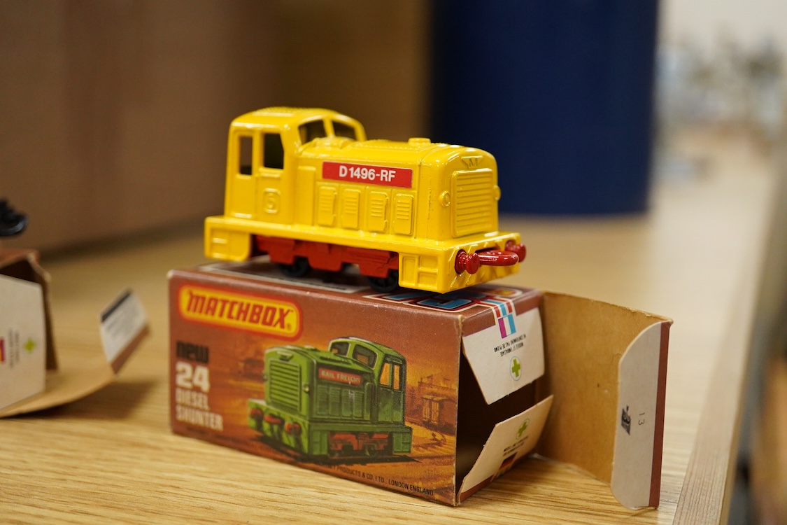 Twelve boxed Matchbox Superfast and Rola-matics 1-75 vehicles; VW Golf (7), petrol tanker (14), Badger (16), Blaze Buster (22), Atlas truck (23), diesel shunter (24), flat car with container (25), passenger coach (44), K